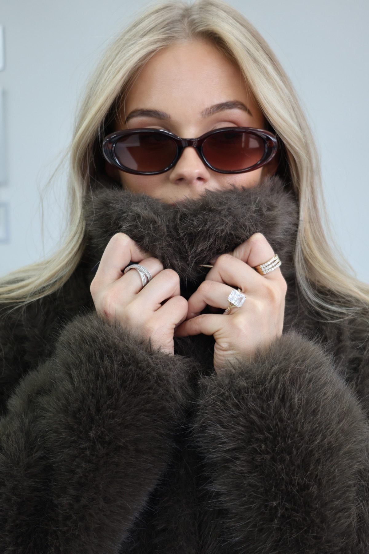 Model in a fur coat and sunglasses wearing diamond rings
