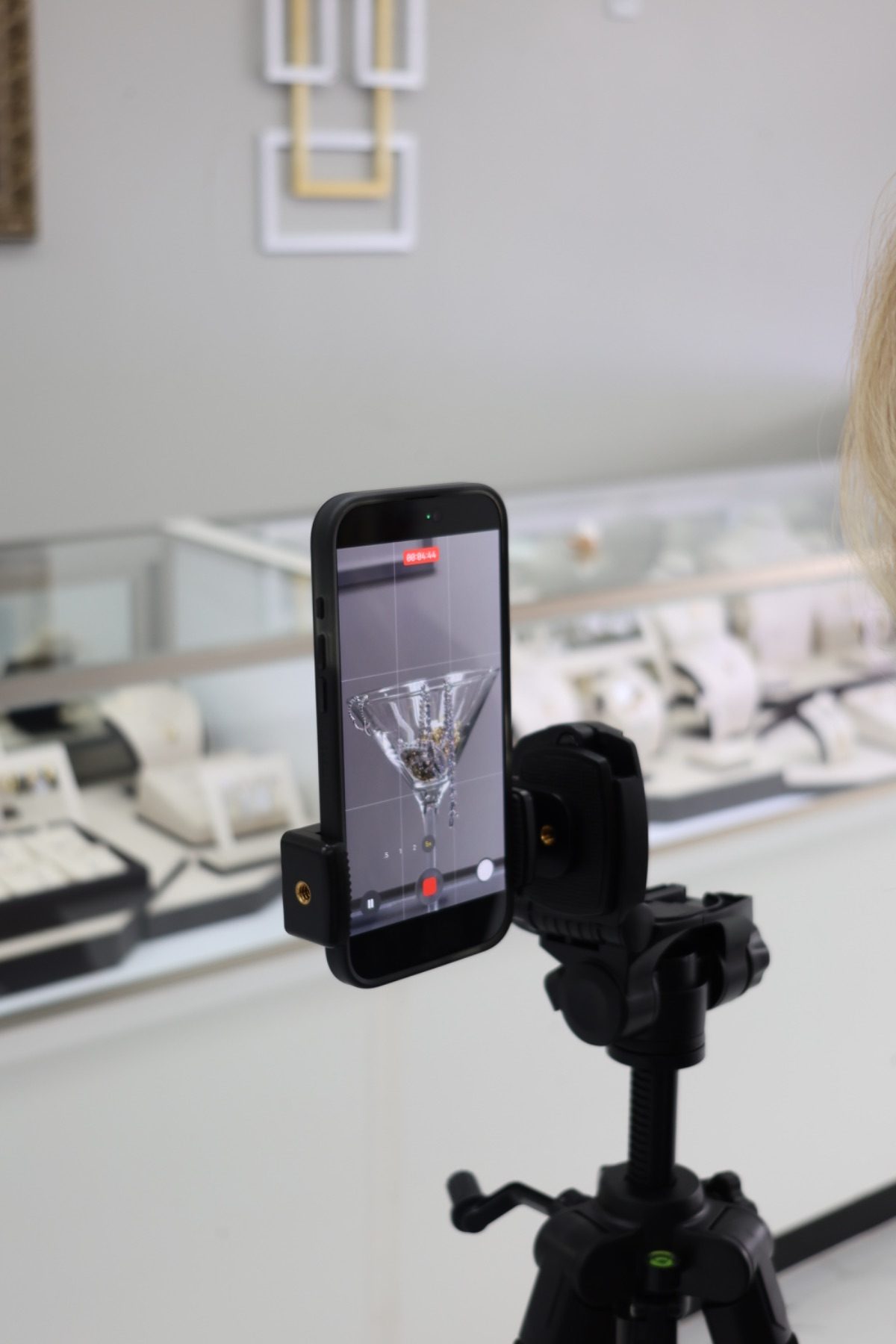 Phone on a tripod recording jewelry content inside a showroom