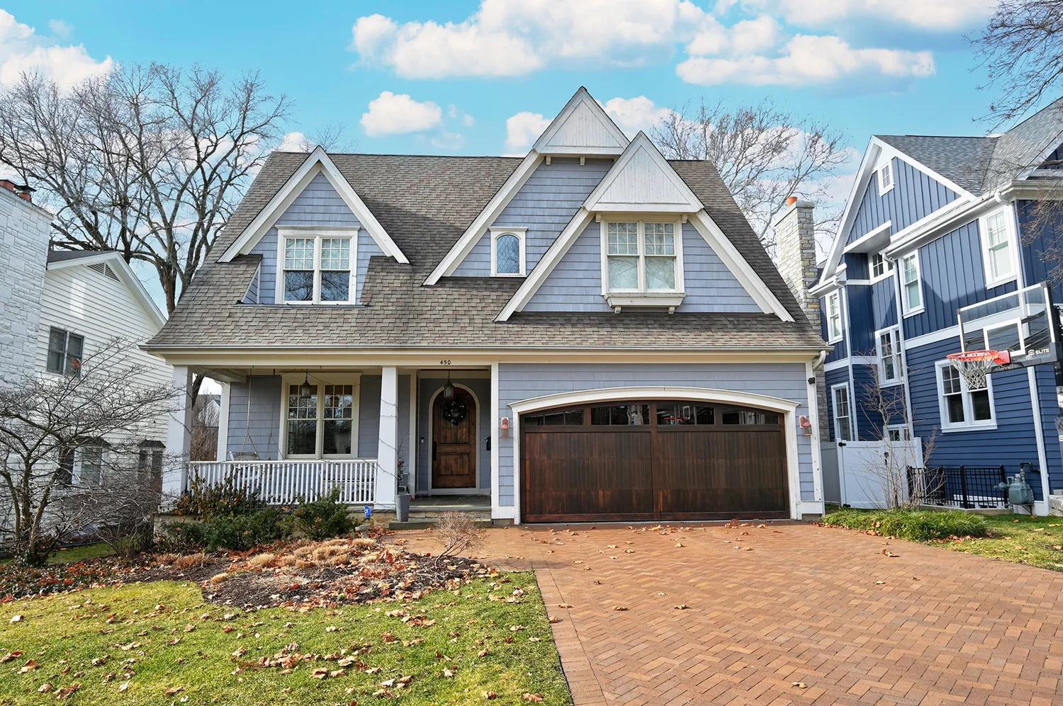 Susan Cook Homes — blue shingle-style home with a brick driveway